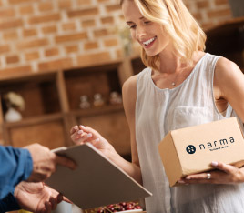 Mujer recibiendo una caja de Narma con su tratamiento de Terapia de Reemplazo Hormonal personalizado.